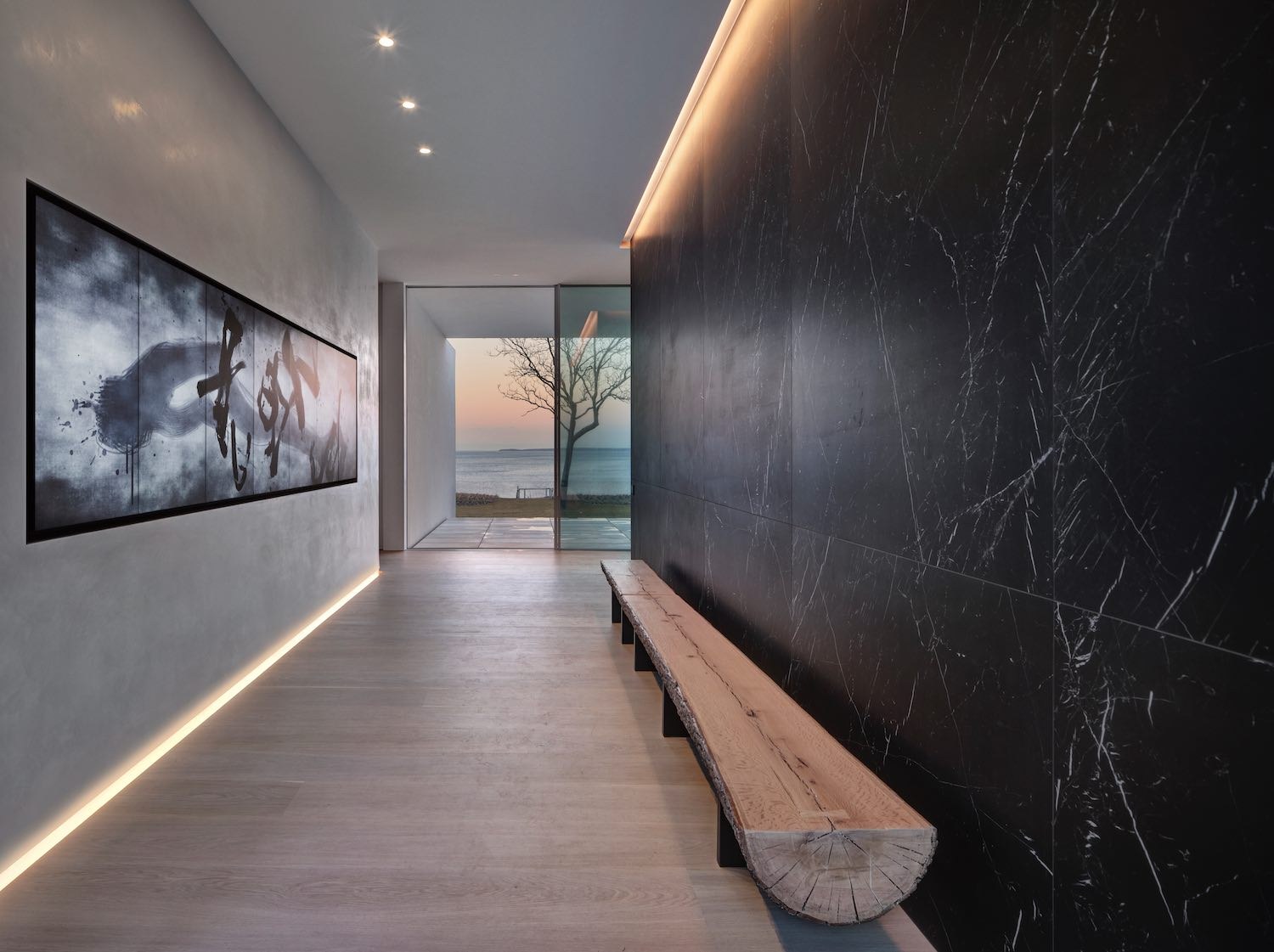 Gallery hallway with black marble wall and water view